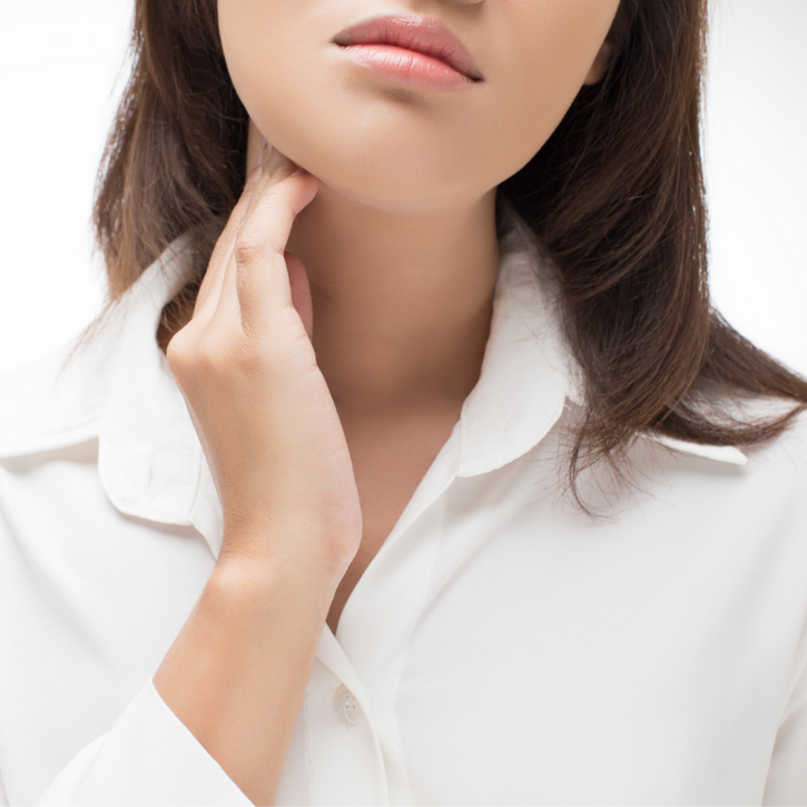 Female touching her thyroid area on her neck.